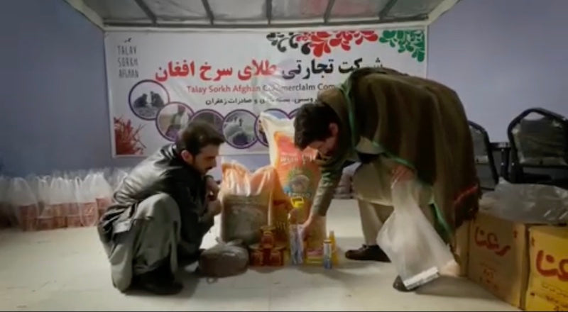 Rumi Spice and Girls' Force provided winter food for 129 Afghan families in 2021, here 2 men sort out the food donations in Herat